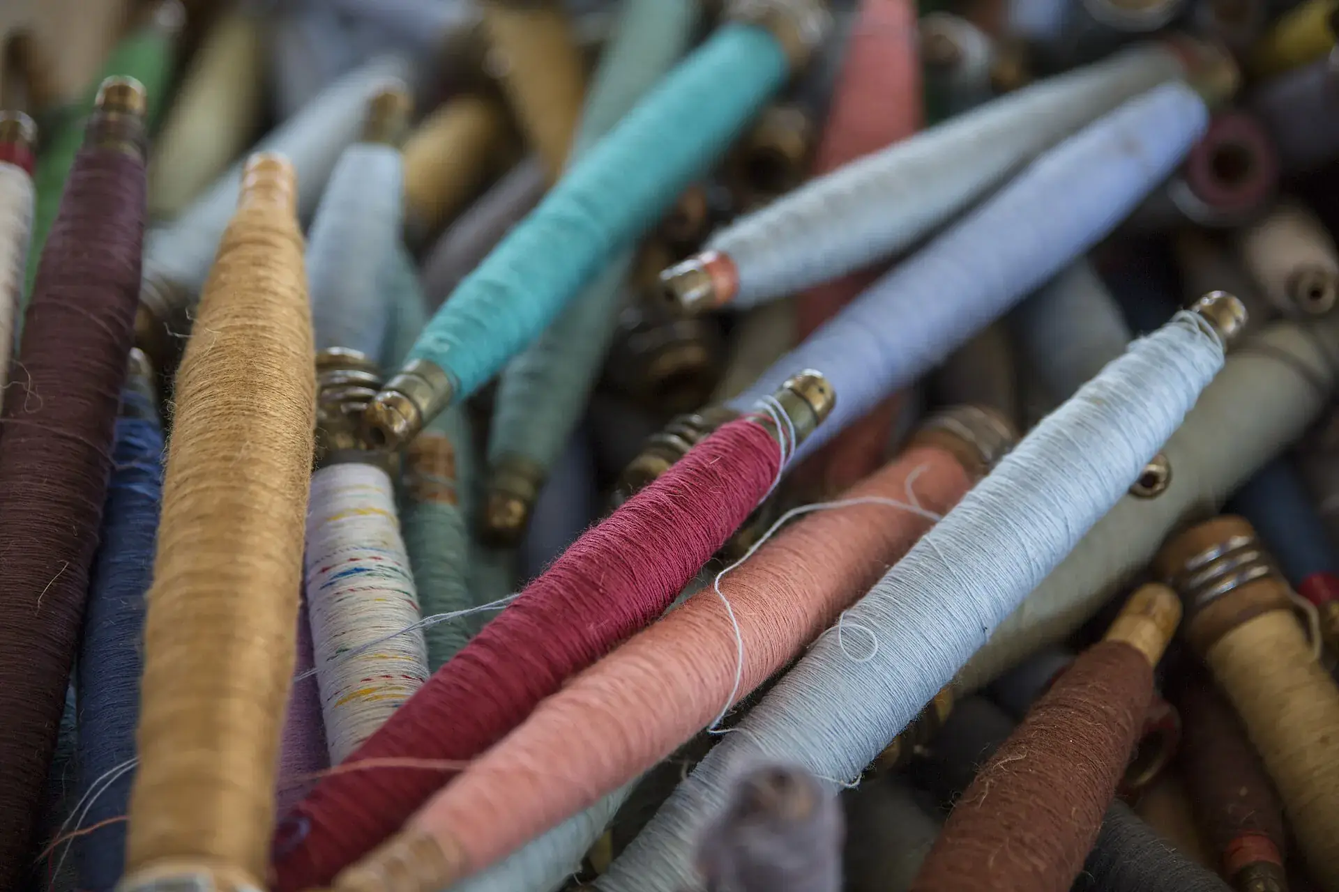 A pile of thread spools in muted colours